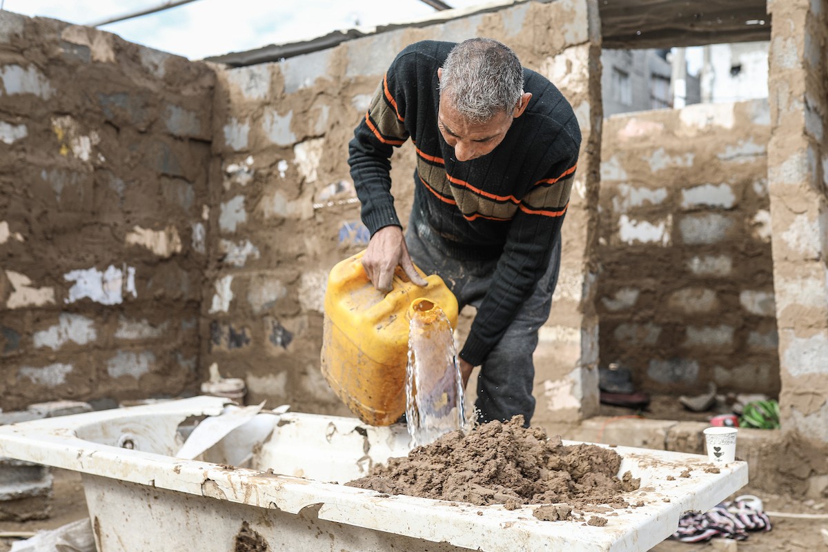 الفلسطيني أحمد المبحوح، مريض سرطان، يبني منزلاً طينياً بيديه في مخيم البريج للاجئين وسط قطاع غزة، 15 ديسمبر/كانون الأول 2025. عدسة: رمزي أبو عامر