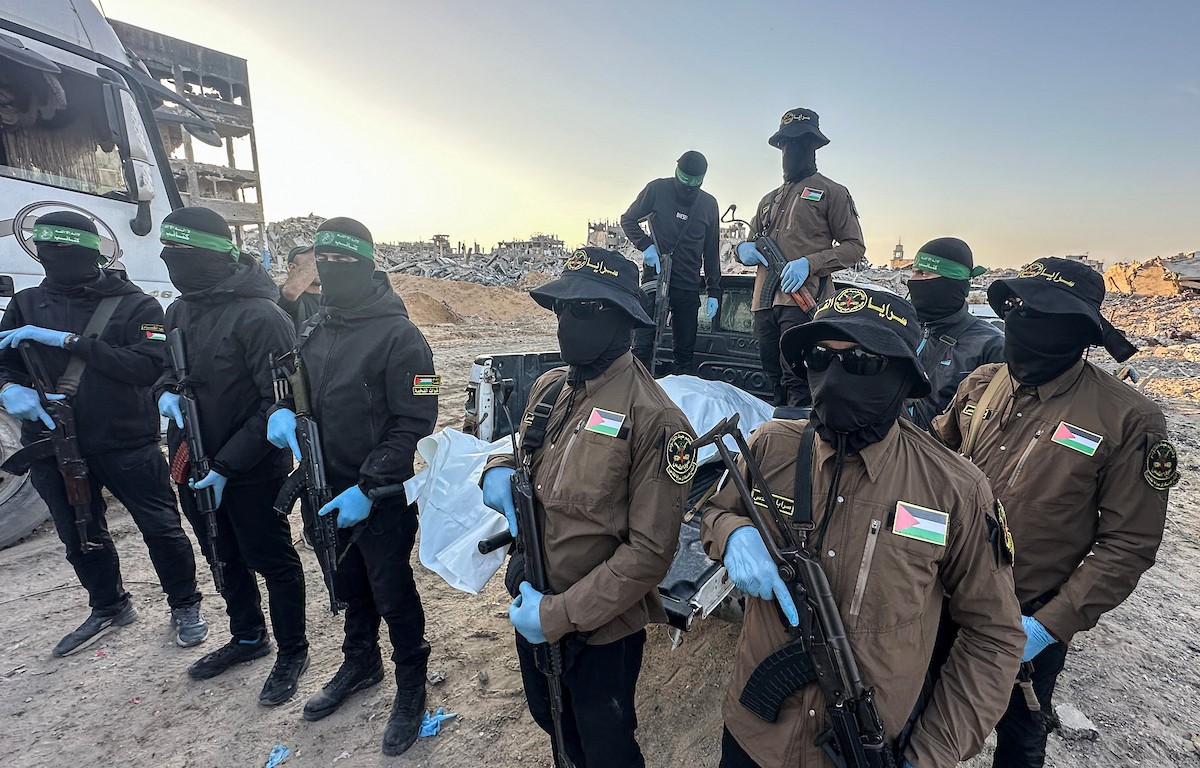 مسلحون من حماس والجهاد الإسلامي في فلسطين يسلمون لأفراد الصليب الأحمر جثة استعادوها من بيت لاهيا قبل تسليمها لإسرائيل لتحديد ما إذا كانت تعود لأحد الرهائن، شمال قطاع غزة، 3 ديسمبر/كانون الأول 2025