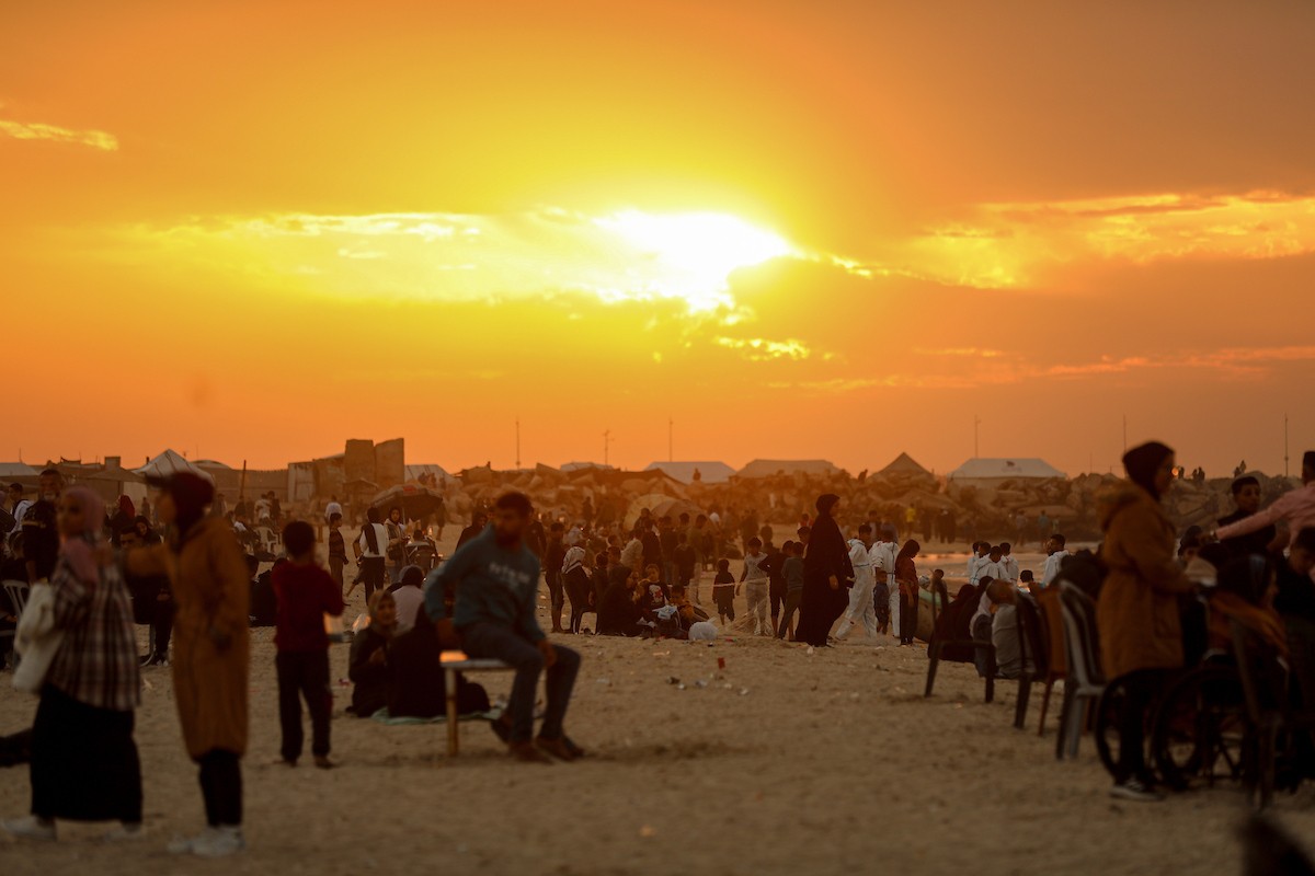 يقضي فلسطينيون نازحون وقتًا على الشاطئ مقابل خيامهم الممتدة على طول ميناء غزة، في غزة، 5 ديسمبر/كانون الأول 2025. تصوير: عمر أشتوي