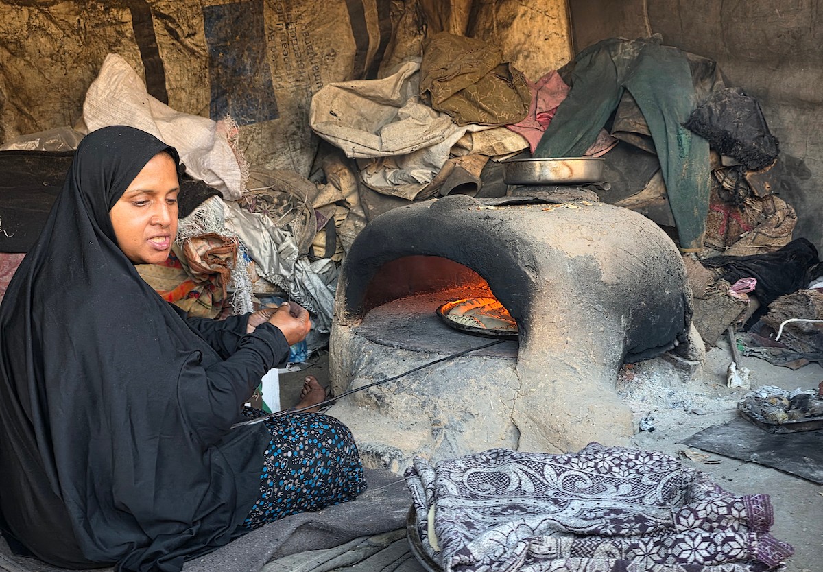 يتجمع فلسطينيون حول أفران طينية مؤقتة لطهي الطعام في قطاع غزة، بعد عشرة أسابيع من وقف إطلاق النار، في ظل شحّ غاز الطهي بسبب القيود الإسرائيلية على دخوله إلى القطاع