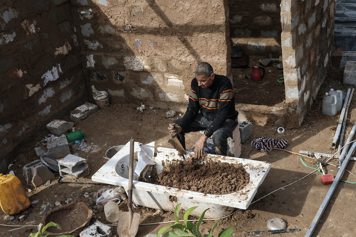 الفلسطيني أحمد المبحوح، مريض سرطان، يبني منزلاً طينياً بيديه في مخيم البريج للاجئين وسط قطاع غزة، 15 ديسمبر/كانون الأول 2025. عدسة: رمزي أبو عامر