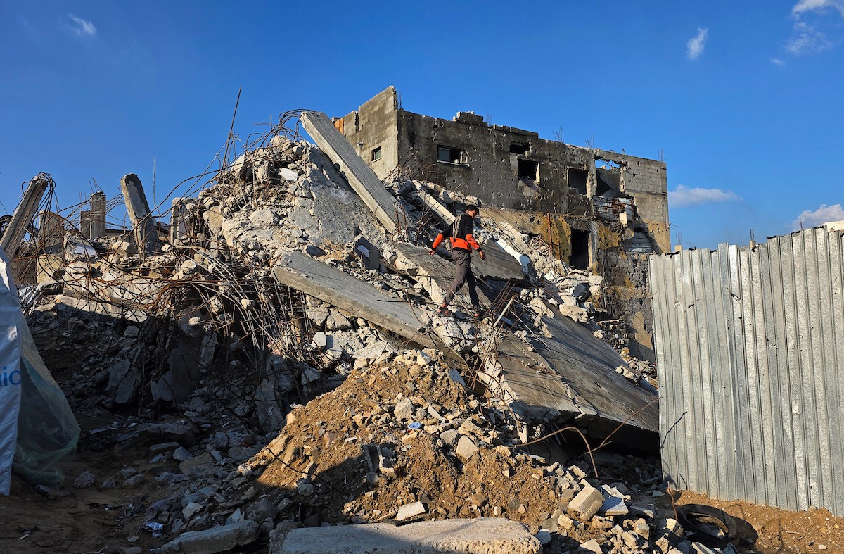 الفلسطيني هشام أبو عية يبني مأوى مؤقت لعائلته المكونة من ثمانية أفراد باستخدام قضبان حديدية استخرجها من أنقاض منزله الذي دُمر في هجمات إسرائيلية بمنطقة بطن السمين في خان يونس،  19 ديسمبر/كانون الأول 2025. تصوير: طارق محمد/ (APA )