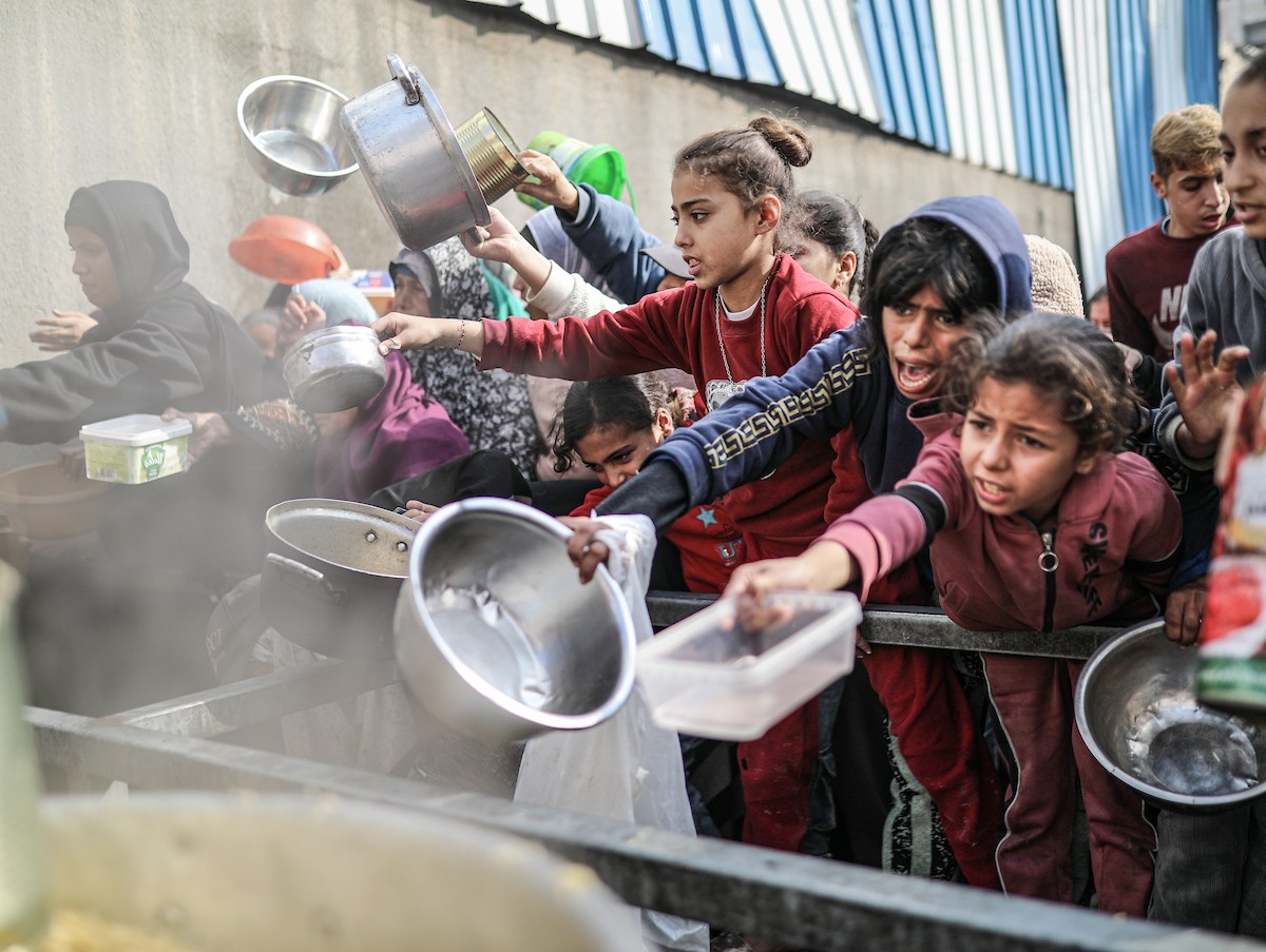يصطفّ فلسطينيون لتلقّي الطعام من مطبخ خيري في تجمع للنازحين بمخيم النصيرات للاجئين، وسط قطاع غزة. ١٧ ديسمبر/كانون الأول ٢٠٢٥. تصوير: رمزي أبو عامر / (apa)