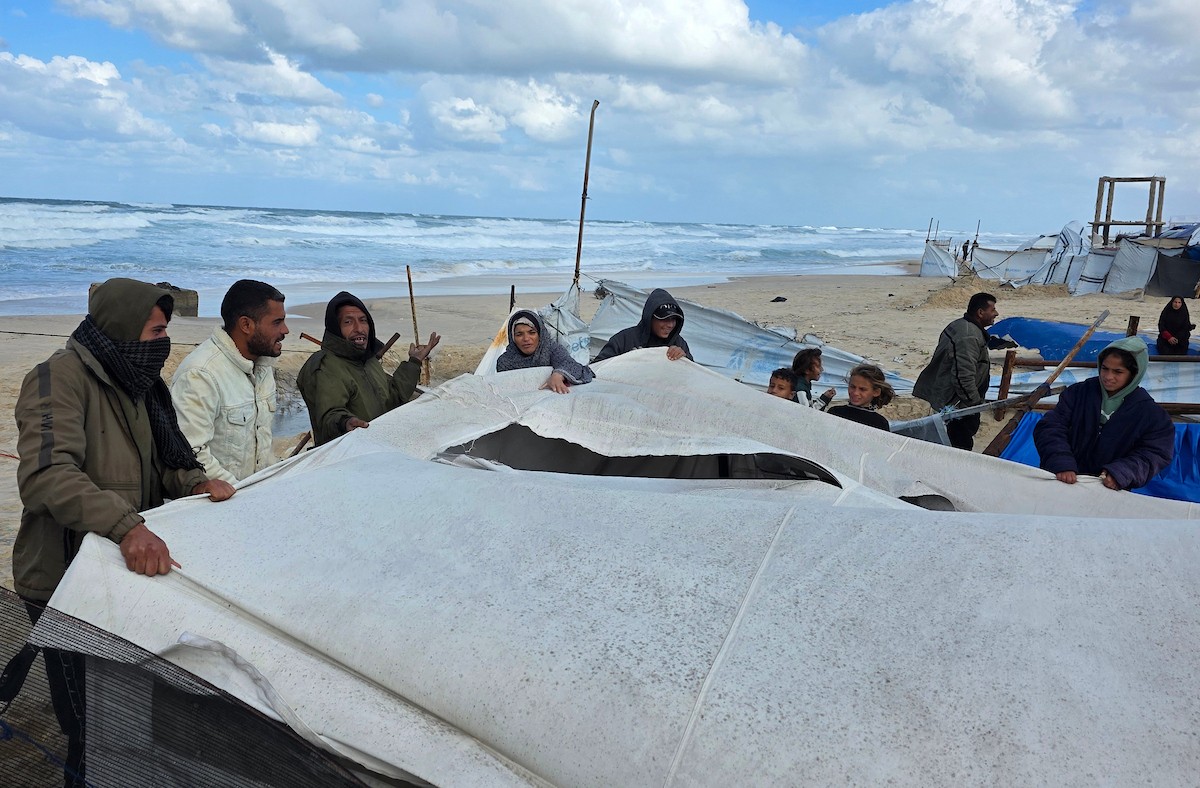 يُكافح الفلسطينيون النازحون، المقيمون في خيام مؤقتة، من أجل البقاء في ظل ظروف قاسية، حيث تجتاح الأمطار والعواصف الشديدة منطقة المواصي، غرب خان يونس، جنوب قطاع غزة، في 28 ديسمبر/كانون الأول 2025. (صورة: طارق محمد)