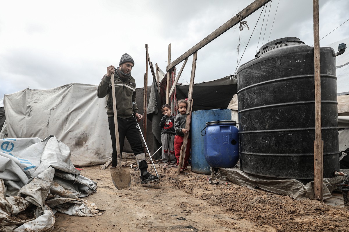 أحمد أبو ليلى أب لخمسة أطفال أصيب في الحرب  يحاول إصلاح خيمته بعد أن تضررت جراء الأمطار الغزيرة والرياح العاتية التي اجتاحت مخيم النصيرات وسط قطاع غزة، 28 ديسمبر/كانون الأول 2025.تصوير: معز صالحي