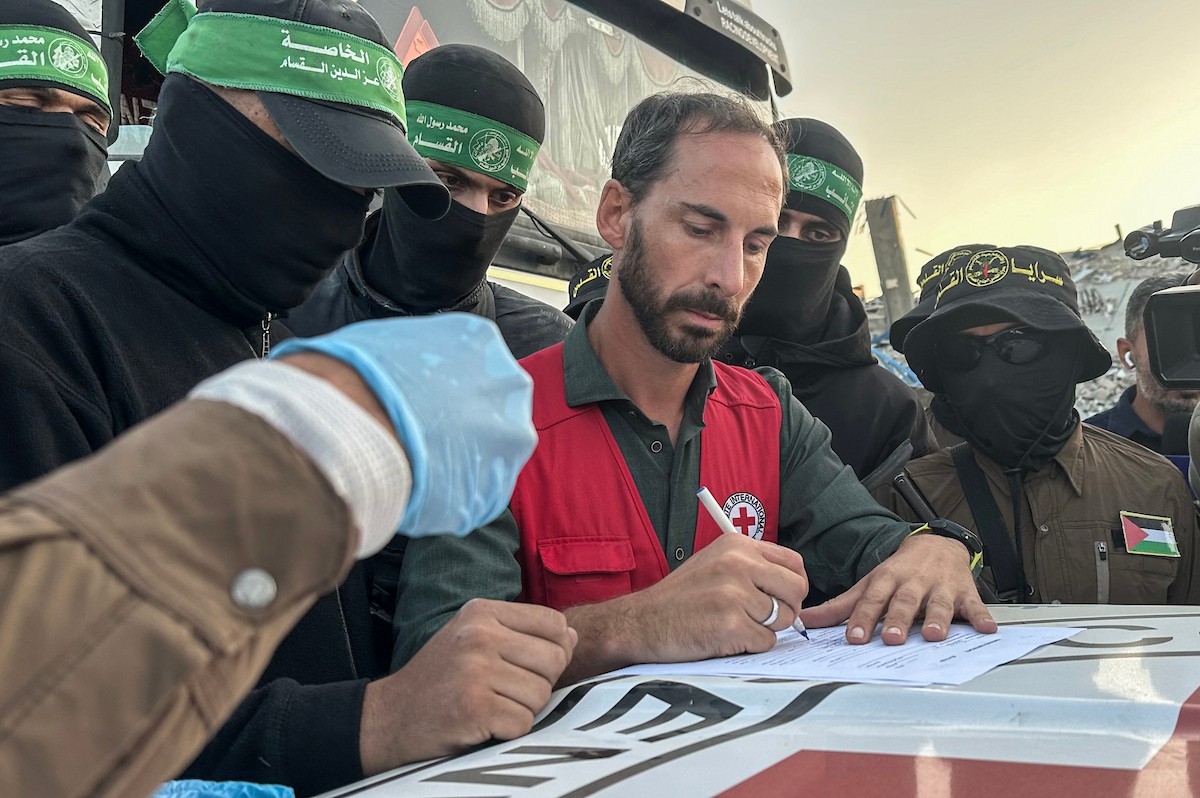 مسلحون من حماس والجهاد الإسلامي في فلسطين يسلمون لأفراد الصليب الأحمر جثة استعادوها من بيت لاهيا قبل تسليمها لإسرائيل لتحديد ما إذا كانت تعود لأحد الرهائن، شمال قطاع غزة، 3 ديسمبر/كانون الأول 2025