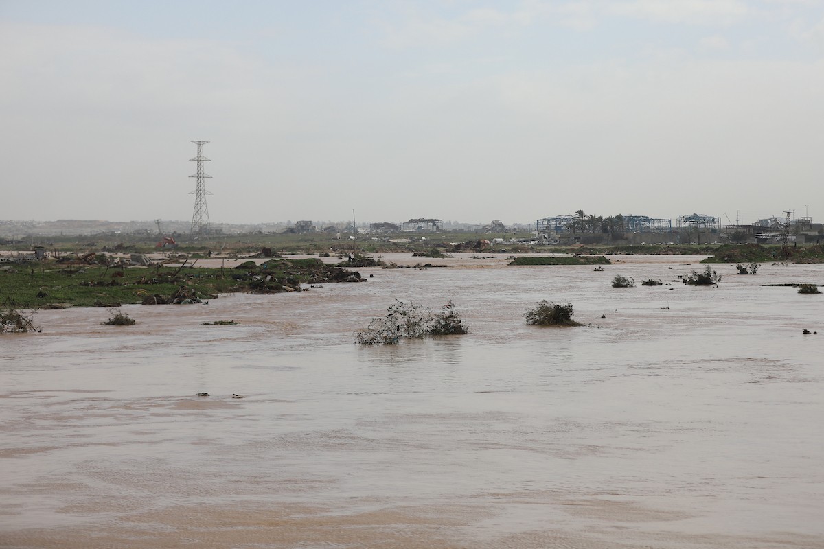 فتح الجيش الإسرائيلي مجرى وادي غزة، مما أدى إلى ارتفاع منسوب المياه إلى مستوى الجسر. وقد فاقم هذا الوضع معاناة العائلات النازحة التي كانت تقيم في خيام بالمنطقة بعد أن فاض الوادي وجرف خيامها، 29 ديسمبر/كانون الأول 2025. صورة: رمزي أبو عامر