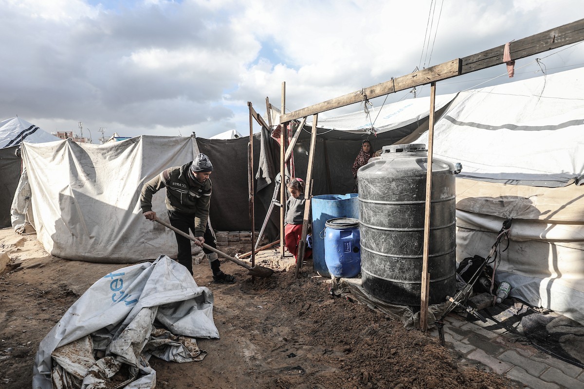 أحمد أبو ليلى أب لخمسة أطفال أصيب في الحرب  يحاول إصلاح خيمته بعد أن تضررت جراء الأمطار الغزيرة والرياح العاتية التي اجتاحت مخيم النصيرات وسط قطاع غزة، 28 ديسمبر/كانون الأول 2025.تصوير: معز صالحي