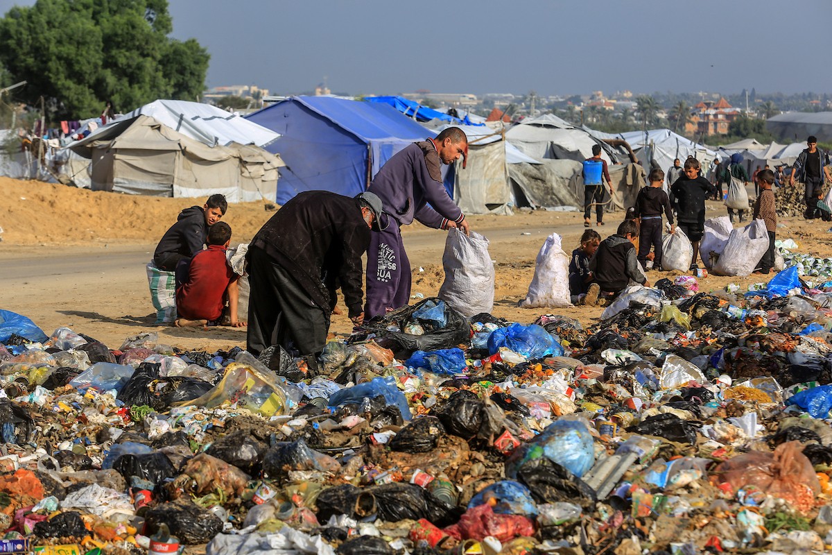 ١٣ ديسمبر/كانون الأول ٢٠٢٥، الأراضي الفلسطينية، نازحون فلسطينيون يبحثون في القمامة في مكب النفايات شمال خان يونس، بحثًا عن البلاستيك أو الورق لإشعال النار للطهي، بسبب انقطاع الغاز. ( عبد رحيم خطيب/وكالة الأنباء الألمانية عبر زوما برس)