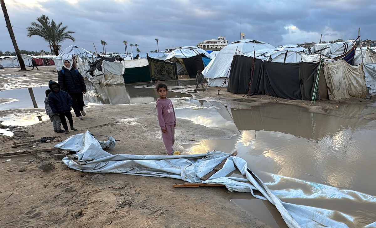 يُكافح الفلسطينيون النازحون، المقيمون في خيام مؤقتة، من أجل البقاء في ظل ظروف قاسية، حيث تجتاح الأمطار والعواصف الشديدة دير البلح، وسط قطاع غزة، في 28 ديسمبركانون الأول 2025. صورة أحمد إبراهيم(APA)