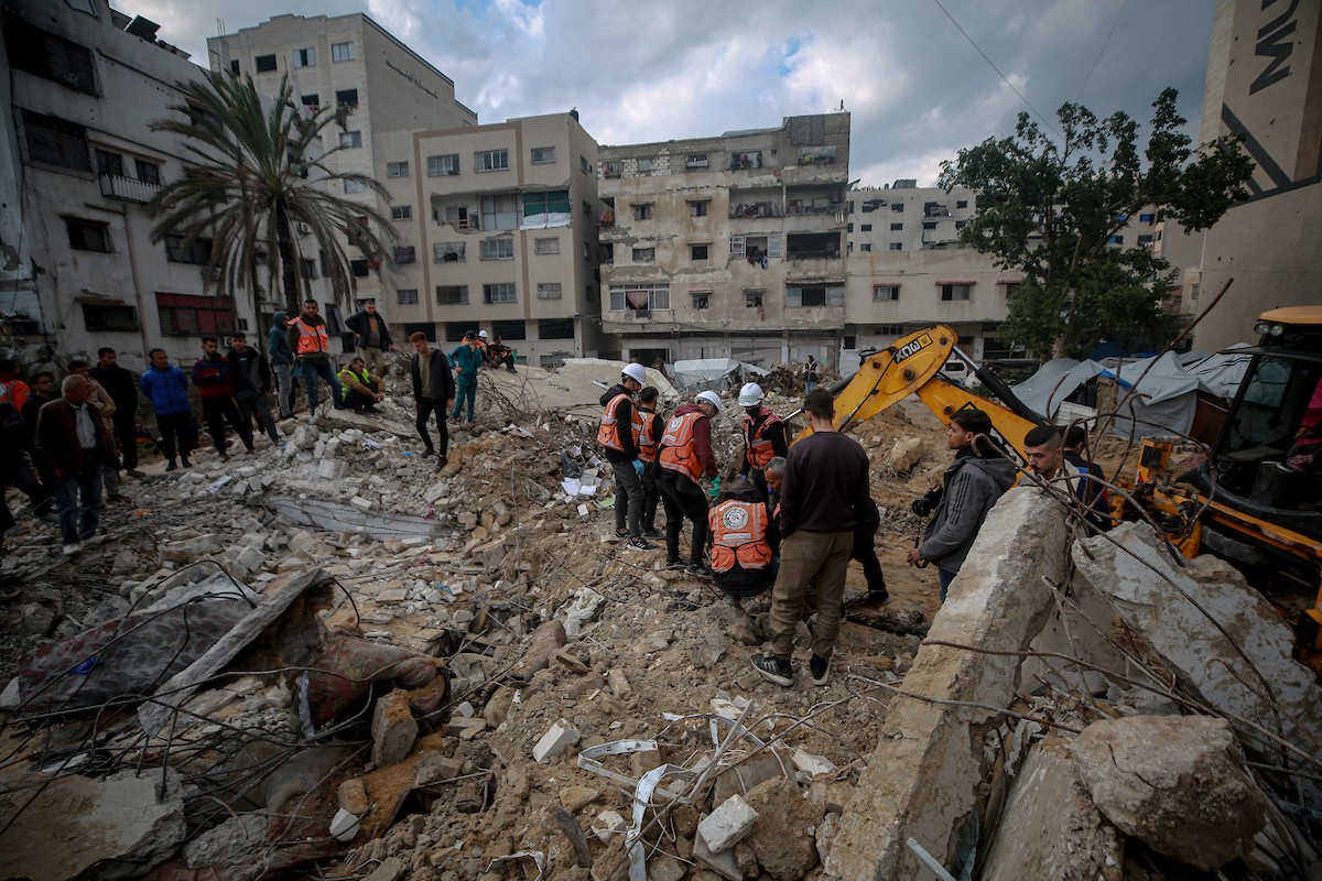 عمال الدفاع المدني الفلسطيني يبحثون عن جثث في مبنى منهار يعود لعائلة سالم، استُهدف بغارات إسرائيلية في بداية الحرب، في شارع الجلاء بمدينة غزة، يوم الاثنين 15 ديسمبر/كانون الأول 2025. صورة: عمر أشتوي
