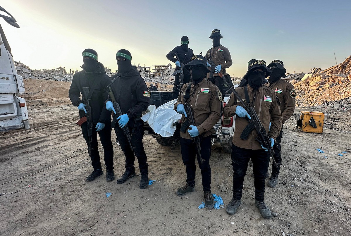 مسلحون من حماس والجهاد الإسلامي في فلسطين يسلمون لأفراد الصليب الأحمر جثة استعادوها من بيت لاهيا قبل تسليمها لإسرائيل لتحديد ما إذا كانت تعود لأحد الرهائن، شمال قطاع غزة، 3 ديسمبر/كانون الأول 2025