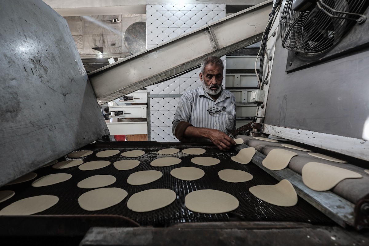 عمال فلسطينيون يعيدون تشغيل أحد أقدم المخابز في مخيم النصيرات للاجئين بعد إغلاقه لمدة عامين بسبب الحرب (14).jpg