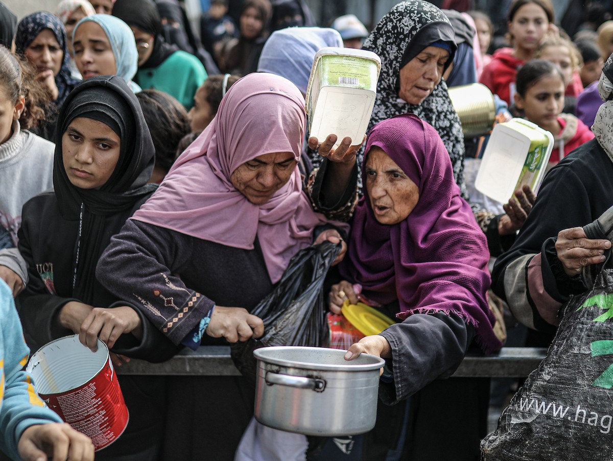يصطفّ فلسطينيون لتلقّي الطعام من مطبخ خيري في تجمع للنازحين بمخيم النصيرات للاجئين، وسط قطاع غزة. ١٧ ديسمبر/كانون الأول ٢٠٢٥. تصوير: رمزي أبو عامر / (apa)