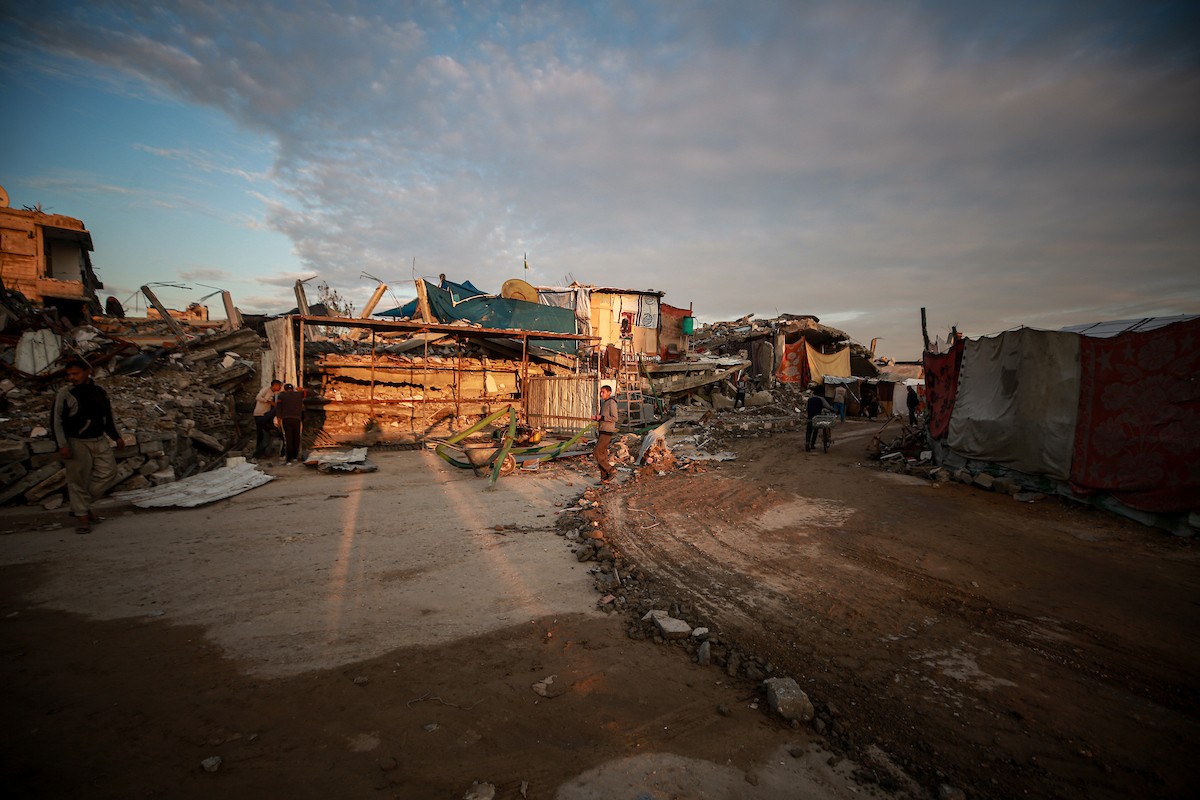 يحاول الفلسطينيون الحفاظ على حياتهم اليومية في مبانٍ مدمرة جزئيًا بعد أن غمرت الأمطار الغزيرة الخيام التي تؤوي نازحين في جباليا، شمال قطاع غزة، في 14 ديسمبر/كانون الأول 2025. صور: عمر أشتوي