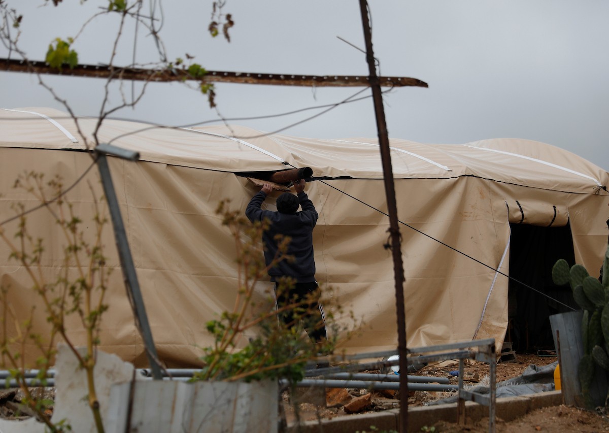 مياه الأمطار تغمر خيمة عائلة حرب التي أقامتها على أنقاض منزلهم الذي هدمه الجيش الإسرائيلي في 9 ديسمبر، في منطقة خلات الفرا، غرب يطا، جنوب الخليل، 29 ديسمبر/كانون الأول 2025. تصوير: مأمون وزواز