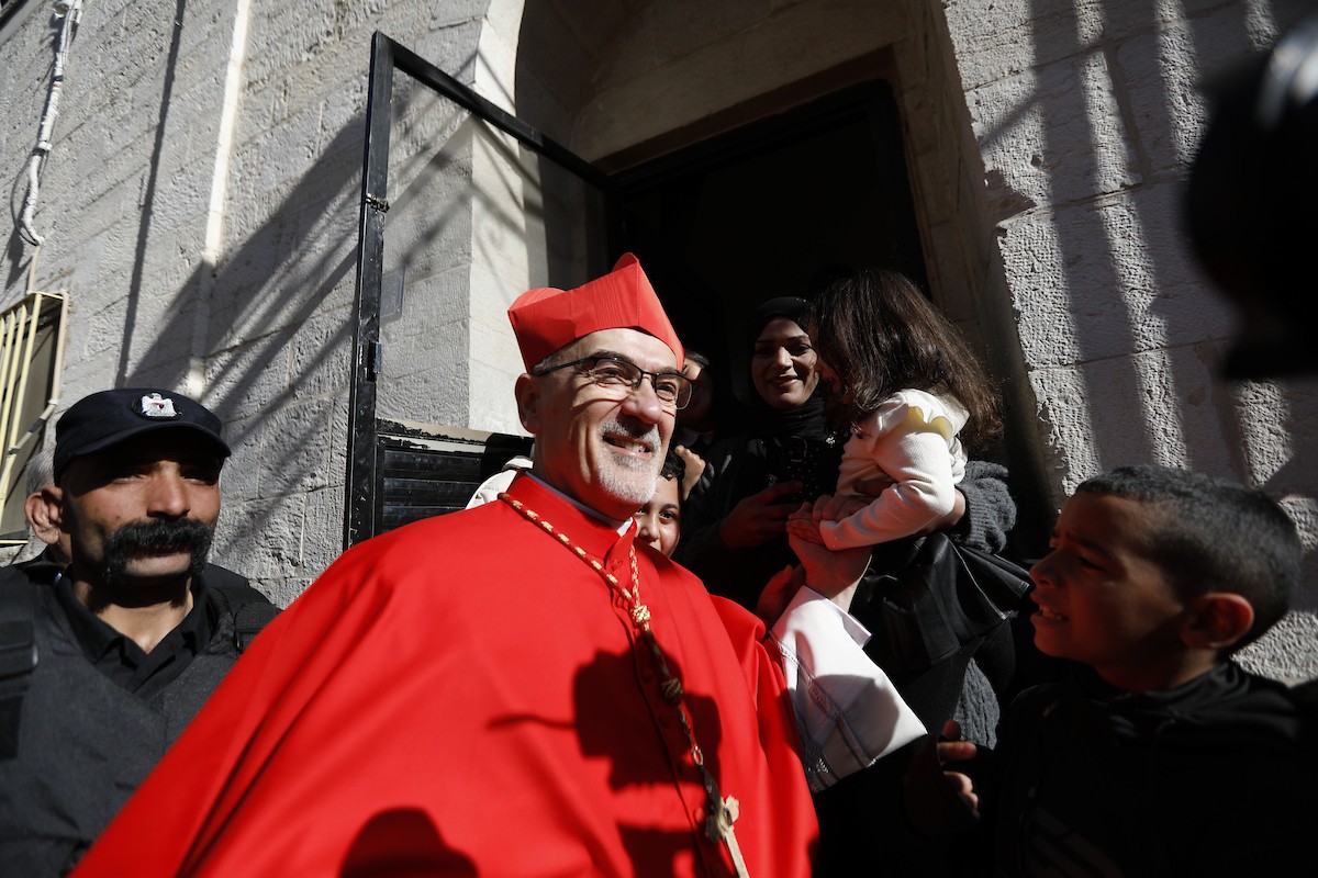 البطريرك اللاتيني للقدس، الكاردينال الإيطالي بييرباتيستا بيتسابالا يستقبل الحجاج والسياح لدى وصوله لترؤس قداس منتصف الليل في كنيسة المهد بمدينة بيت لحم، 24 ديسمبر/كانون الأول 2025،  (صور: مأمون وزواز/ apa)