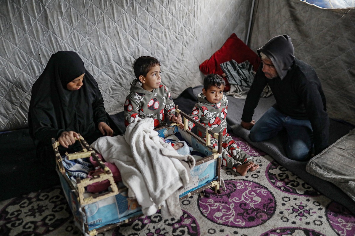 عائلة فلسطينية نازحة مكونة من ستة أفراد  تكافح وسط ظروف غير إنسانية من أجل حماية أطفالها من أجواء الشتاء القارس في  خيمة مهترئة بملعب اليرموك في مدينة غزة، 29 ديسمبر/كانون الأول 2025 صورة: عمر أشتوي