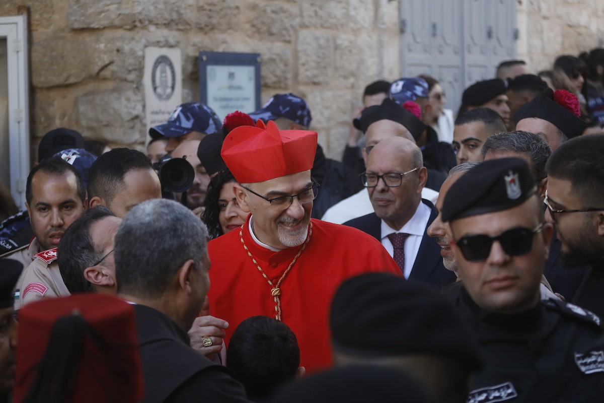 البطريرك اللاتيني للقدس، الكاردينال الإيطالي بييرباتيستا بيتسابالا يستقبل الحجاج والسياح لدى وصوله لترؤس قداس منتصف الليل في كنيسة المهد بمدينة بيت لحم، 24 ديسمبر/كانون الأول 2025،  (صور: مأمون وزواز/ apa)