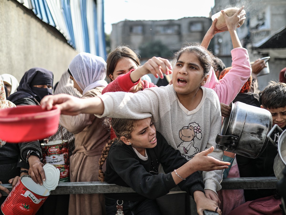 يصطفّ فلسطينيون لتلقّي الطعام من مطبخ خيري في تجمع للنازحين بمخيم النصيرات للاجئين، وسط قطاع غزة. ١٧ ديسمبر/كانون الأول ٢٠٢٥. تصوير: رمزي أبو عامر / (apa)