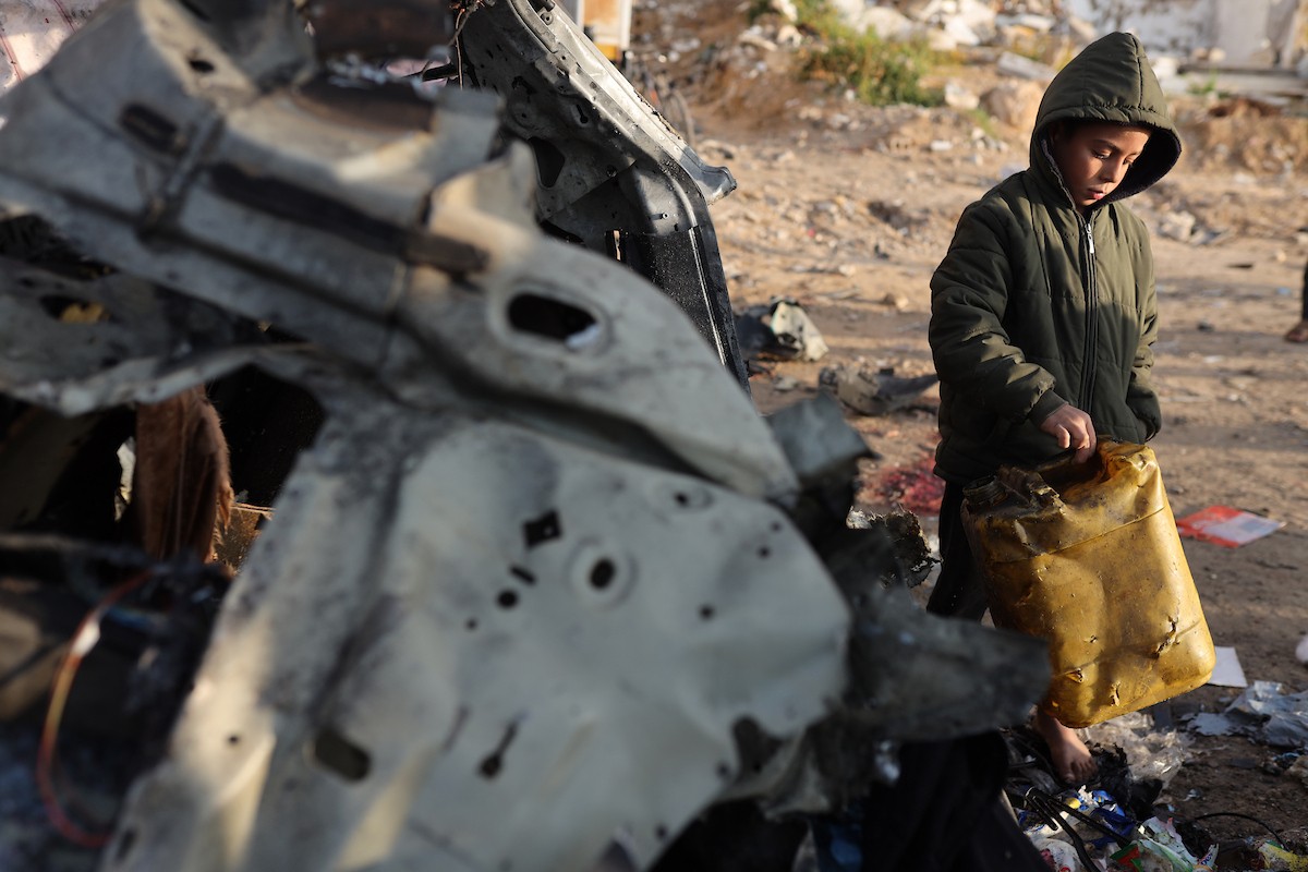 فلسطينيون يتفقدون موقع غارة إسرائيلية استهدفت سيارة على شارع لرشيد غرب مدينة غزة، 13 ديسمبر/كانون الأول 2025. صور: عمر أشتوي