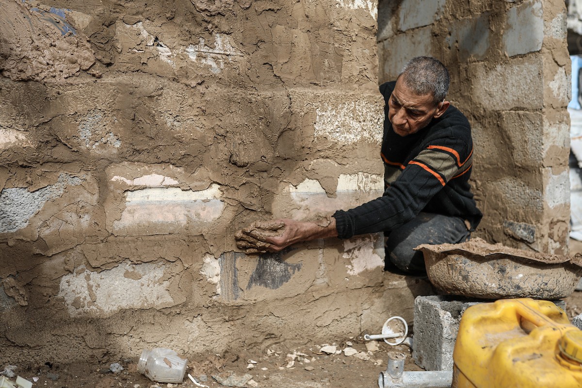 الفلسطيني أحمد المبحوح، مريض سرطان، يبني منزلاً طينياً بيديه في مخيم البريج للاجئين وسط قطاع غزة، 15 ديسمبر/كانون الأول 2025. عدسة: رمزي أبو عامر