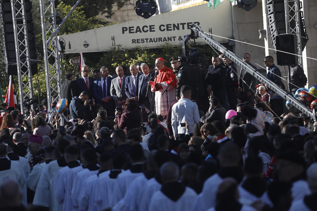 البطريرك اللاتيني للقدس، الكاردينال الإيطالي بييرباتيستا بيتسابالا يستقبل الحجاج والسياح لدى وصوله لترؤس قداس منتصف الليل في كنيسة المهد بمدينة بيت لحم، 24 ديسمبر/كانون الأول 2025،  (صور: مأمون وزواز/ apa)