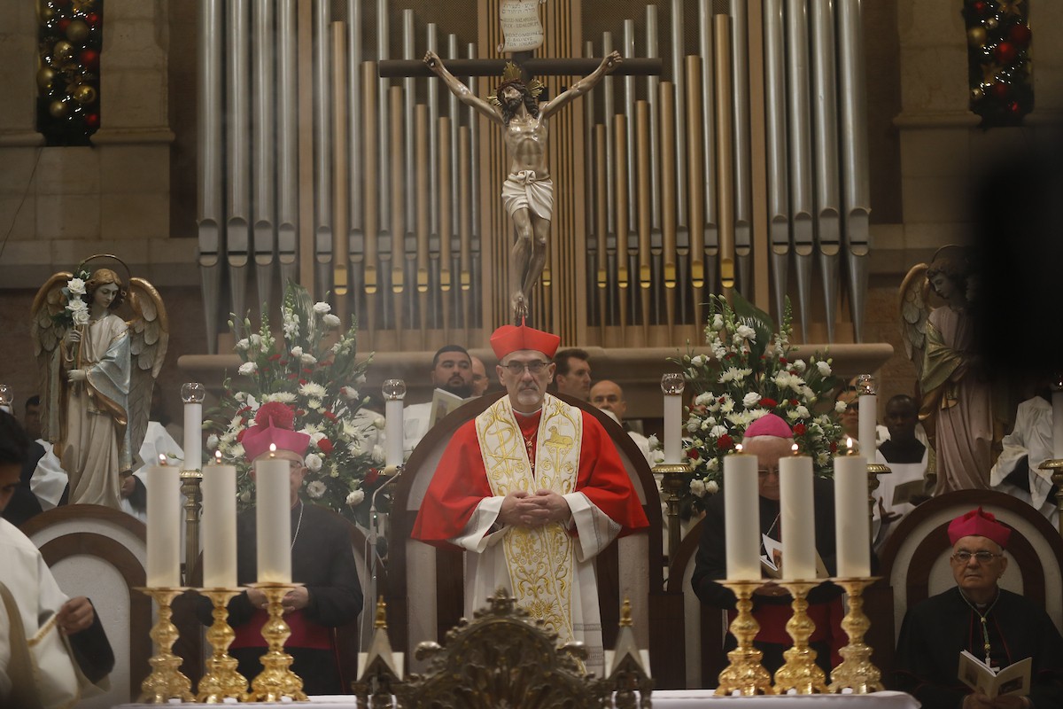 البطريرك اللاتيني للقدس، الكاردينال الإيطالي بييرباتيستا بيتسابالا يستقبل الحجاج والسياح لدى وصوله لترؤس قداس منتصف الليل في كنيسة المهد بمدينة بيت لحم، 24 ديسمبر/كانون الأول 2025،  (صور: مأمون وزواز/ apa)