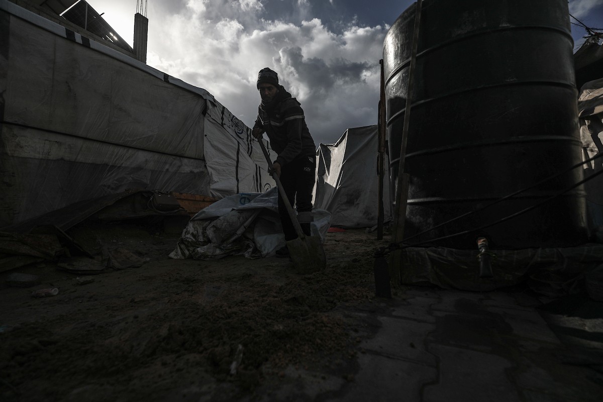 أحمد أبو ليلى أب لخمسة أطفال أصيب في الحرب  يحاول إصلاح خيمته بعد أن تضررت جراء الأمطار الغزيرة والرياح العاتية التي اجتاحت مخيم النصيرات وسط قطاع غزة، 28 ديسمبر/كانون الأول 2025.تصوير: معز صالحي