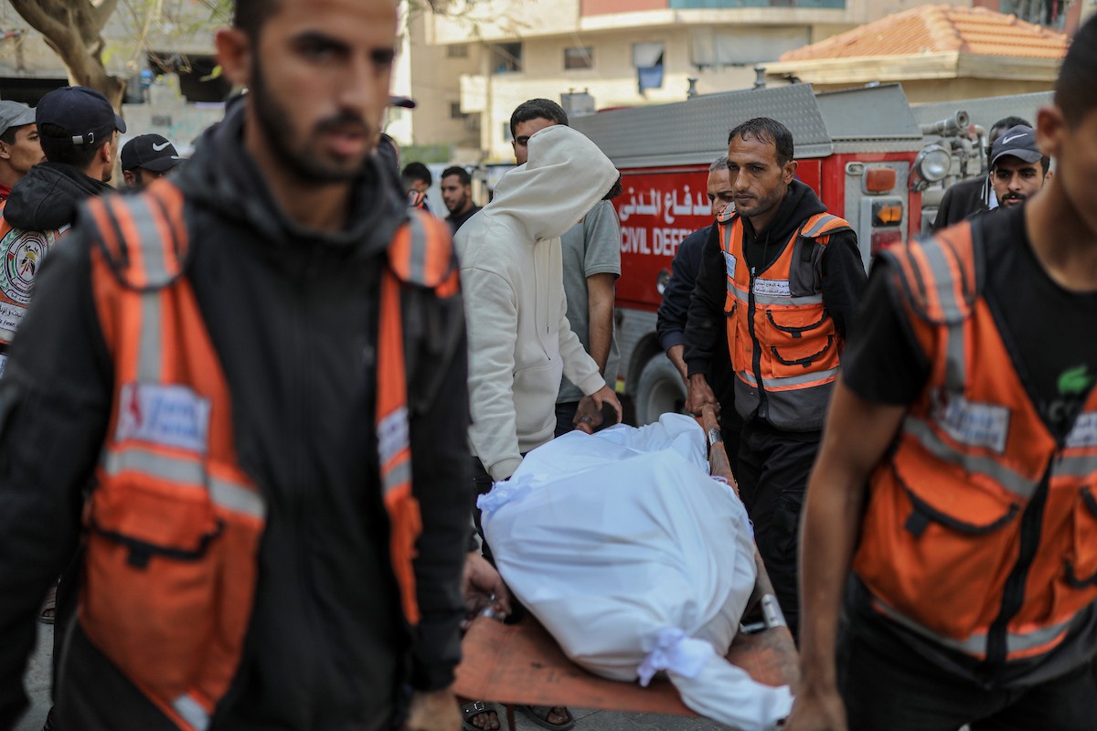 فلسطينيون ينعون ويحملون جثامين عدد من القتلى في غارة إسرائيلية على بيت لاهيا، بينهم أحد عناصر الدفاع المدني، خلال جنازة في مستشفى الشفاء بمدينة غزة