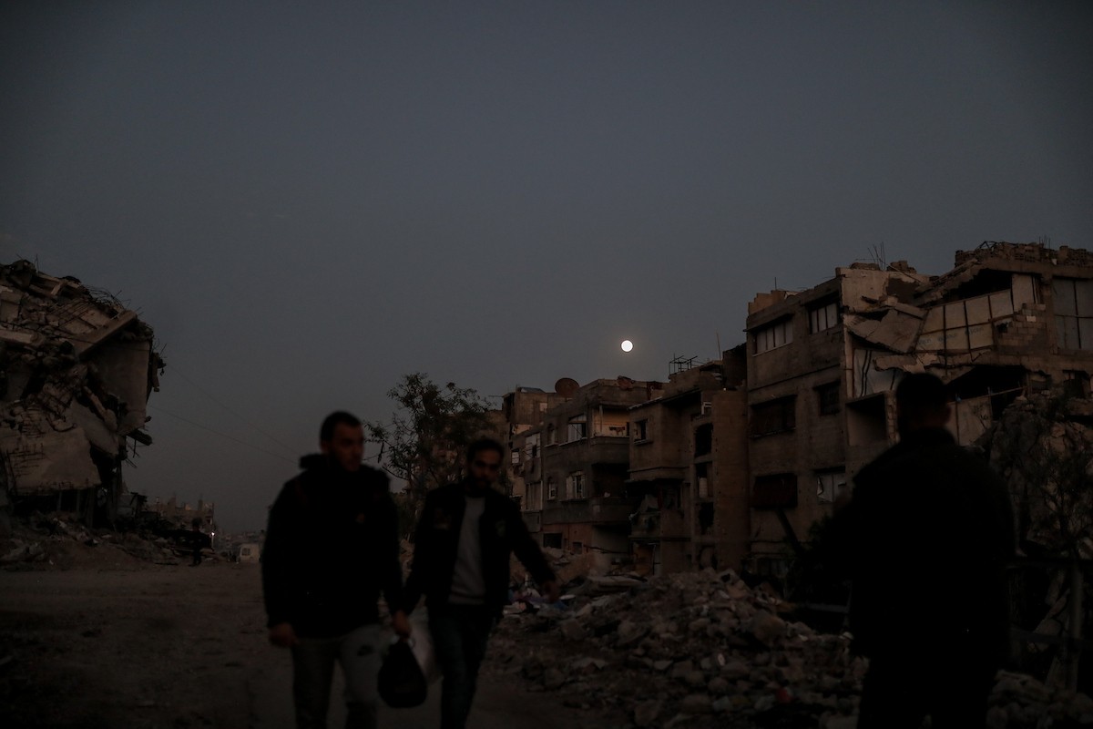 يعيش الفلسطينيون حياتهم اليومية ليلاً في خيام نصبت فوق أنقاض المباني المدمرة في حي الشيخ رضوان وسط مدينة غزة، 5 ديسمبر/كانون الأول 2025.تصوير: عمر أشتوي