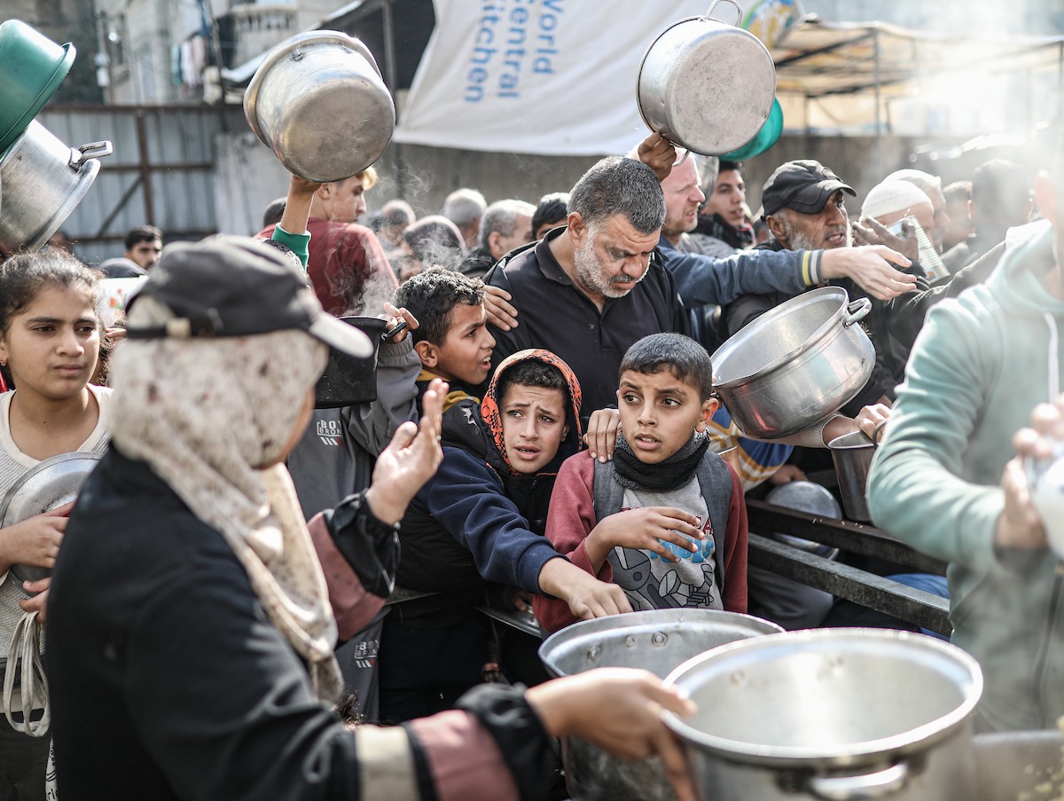 يصطفّ فلسطينيون لتلقّي الطعام من مطبخ خيري في تجمع للنازحين بمخيم النصيرات للاجئين، وسط قطاع غزة. ١٧ ديسمبر/كانون الأول ٢٠٢٥. تصوير: رمزي أبو عامر / (apa)