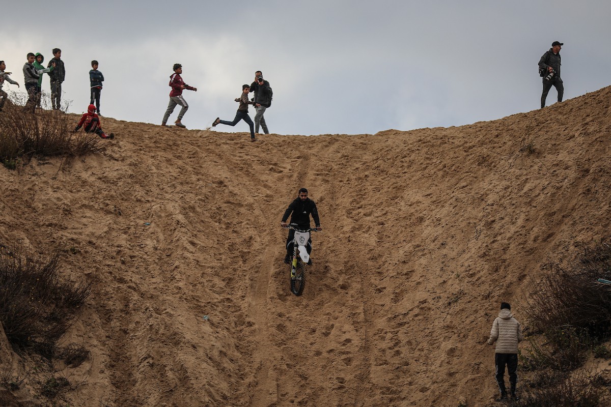 شبان فلسطينيون يركبون الدراجات النارية على الكثبان الرملية في بلدة الزهراء، بعد انقطاع دام عامين عن هذه الرياضة بسبب الحرب واحتلال الجيش الإسرائيلي للمنطقة المعروفة سابقا بمحور