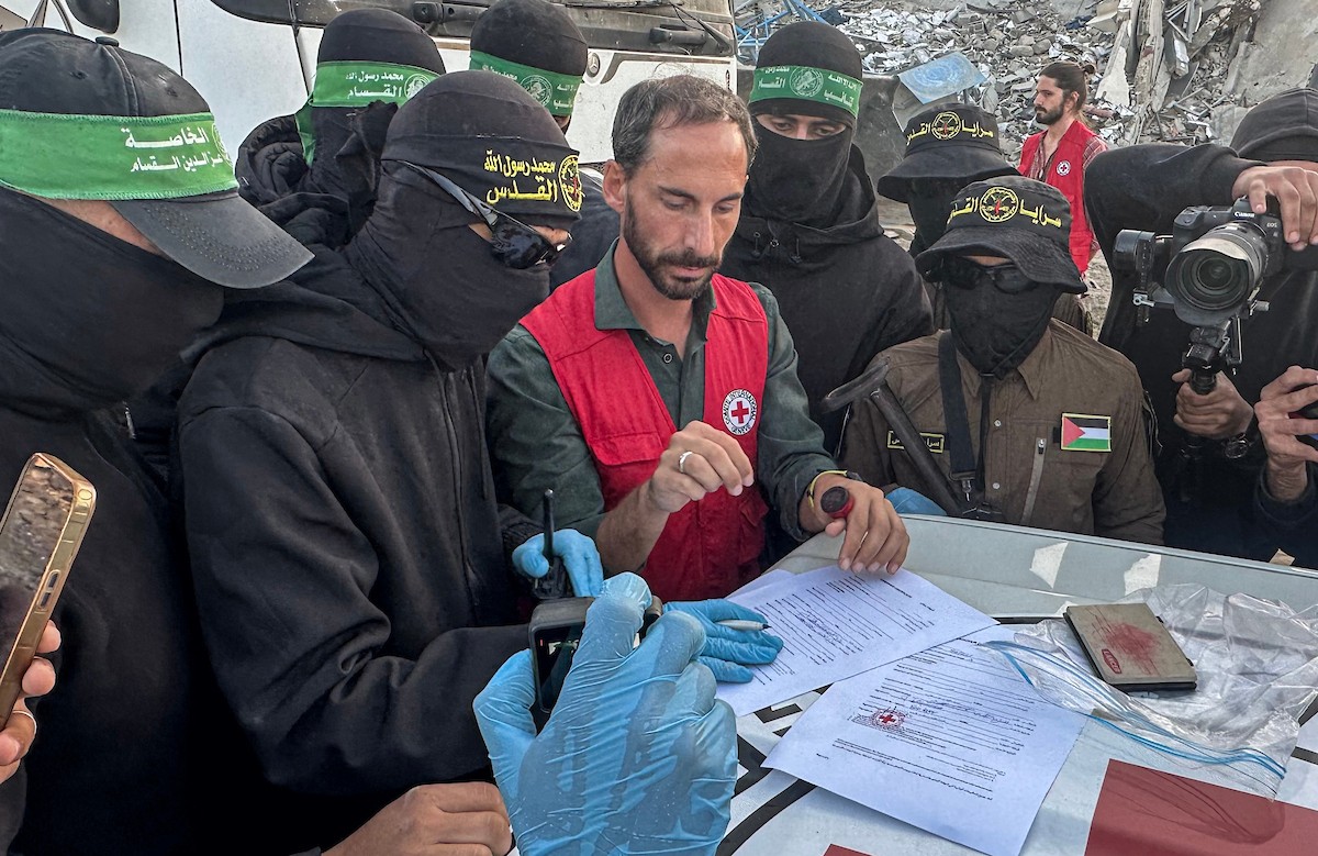 مسلحون من حماس والجهاد الإسلامي في فلسطين يسلمون لأفراد الصليب الأحمر جثة استعادوها من بيت لاهيا قبل تسليمها لإسرائيل لتحديد ما إذا كانت تعود لأحد الرهائن، شمال قطاع غزة، 3 ديسمبر/كانون الأول 2025