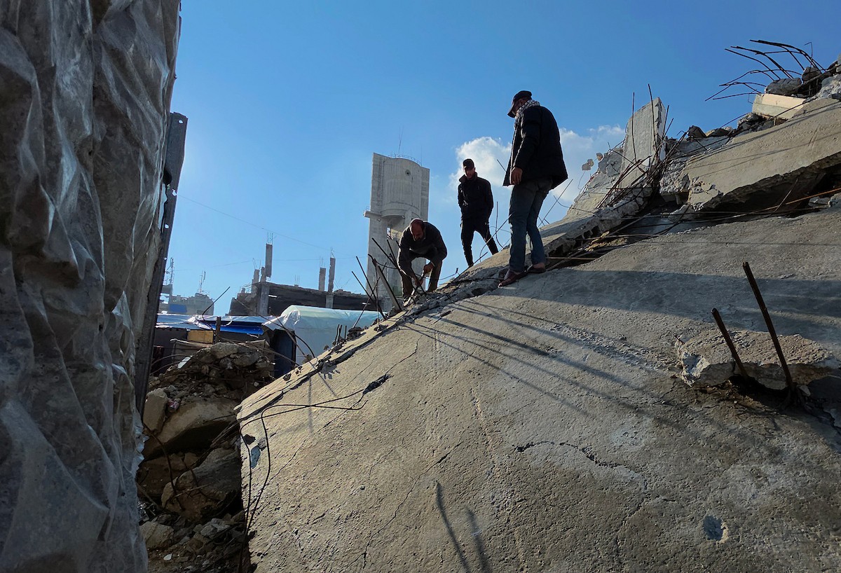 الفلسطيني هشام أبو عية يبني مأوى مؤقت لعائلته المكونة من ثمانية أفراد باستخدام قضبان حديدية استخرجها من أنقاض منزله الذي دُمر في هجمات إسرائيلية بمنطقة بطن السمين في خان يونس،  19 ديسمبر/كانون الأول 2025. تصوير: طارق محمد/ (APA )