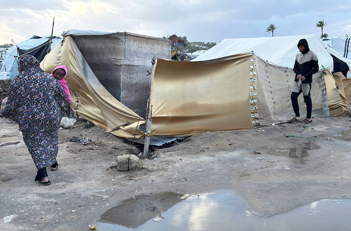 يُكافح الفلسطينيون النازحون، المقيمون في خيام مؤقتة، من أجل البقاء في ظل ظروف قاسية، حيث تجتاح الأمطار والعواصف الشديدة دير البلح، وسط قطاع غزة، في 28 ديسمبركانون الأول 2025. صورة أحمد إبراهيم(APA)