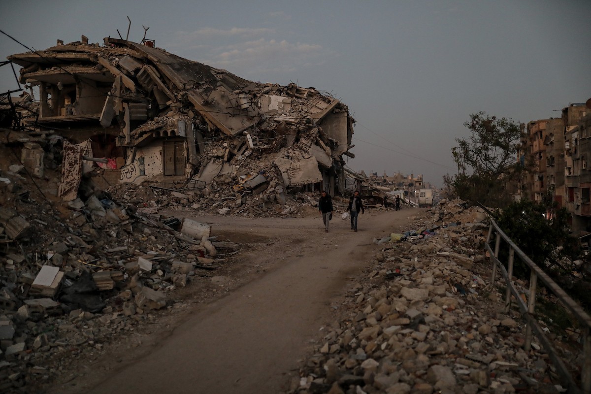 يعيش الفلسطينيون حياتهم اليومية ليلاً في خيام نصبت فوق أنقاض المباني المدمرة في حي الشيخ رضوان وسط مدينة غزة، 5 ديسمبر/كانون الأول 2025.تصوير: عمر أشتوي