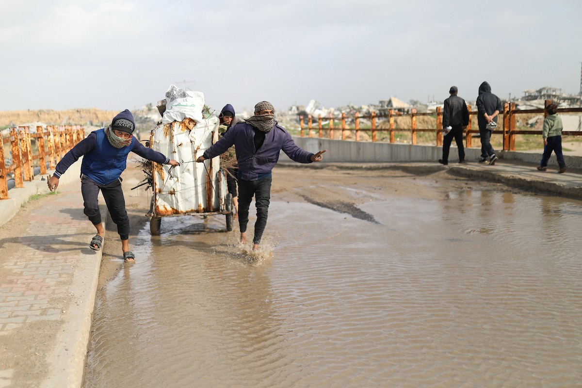 فتح الجيش الإسرائيلي مجرى وادي غزة، مما أدى إلى ارتفاع منسوب المياه إلى مستوى الجسر. وقد فاقم هذا الوضع معاناة العائلات النازحة التي كانت تقيم في خيام بالمنطقة بعد أن فاض الوادي وجرف خيامها، 29 ديسمبر/كانون الأول 2025. صورة: رمزي أبو عامر