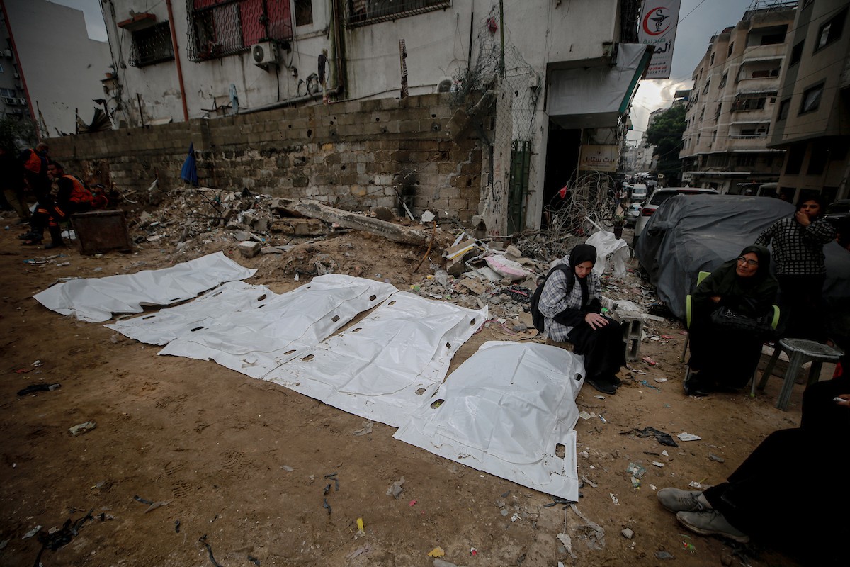 عمال الدفاع المدني الفلسطيني يبحثون عن جثث في مبنى منهار يعود لعائلة سالم، استُهدف بغارات إسرائيلية في بداية الحرب، في شارع الجلاء بمدينة غزة، يوم الاثنين 15 ديسمبر/كانون الأول 2025. صورة: عمر أشتوي