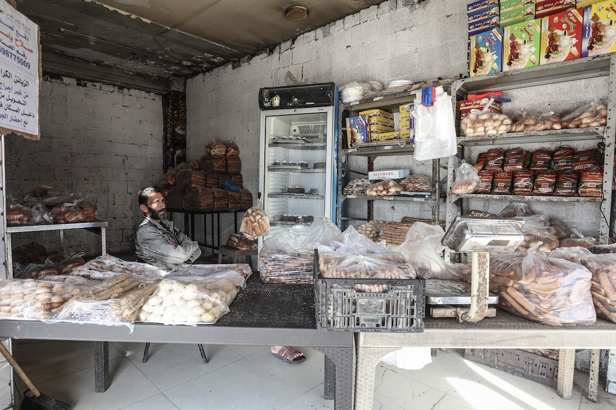 عمال فلسطينيون يعيدون تشغيل أحد أقدم المخابز في مخيم النصيرات للاجئين بعد إغلاقه لمدة عامين بسبب الحرب (6).jpg