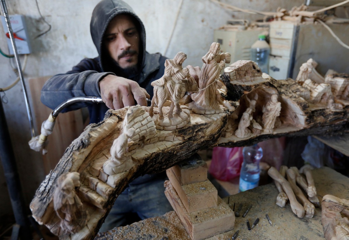 نحت خشب الزيتون في بيت لحم لصنع قطع فنية وهدايا متنوعة، تشمل منحوتات دينية وزخارف تقليدية وتذكارات، استعدادًا لعيد الميلاد، 18 ديسمبر/كانون الأول 2025 تصوير: مأمون وزواز/ (apa)