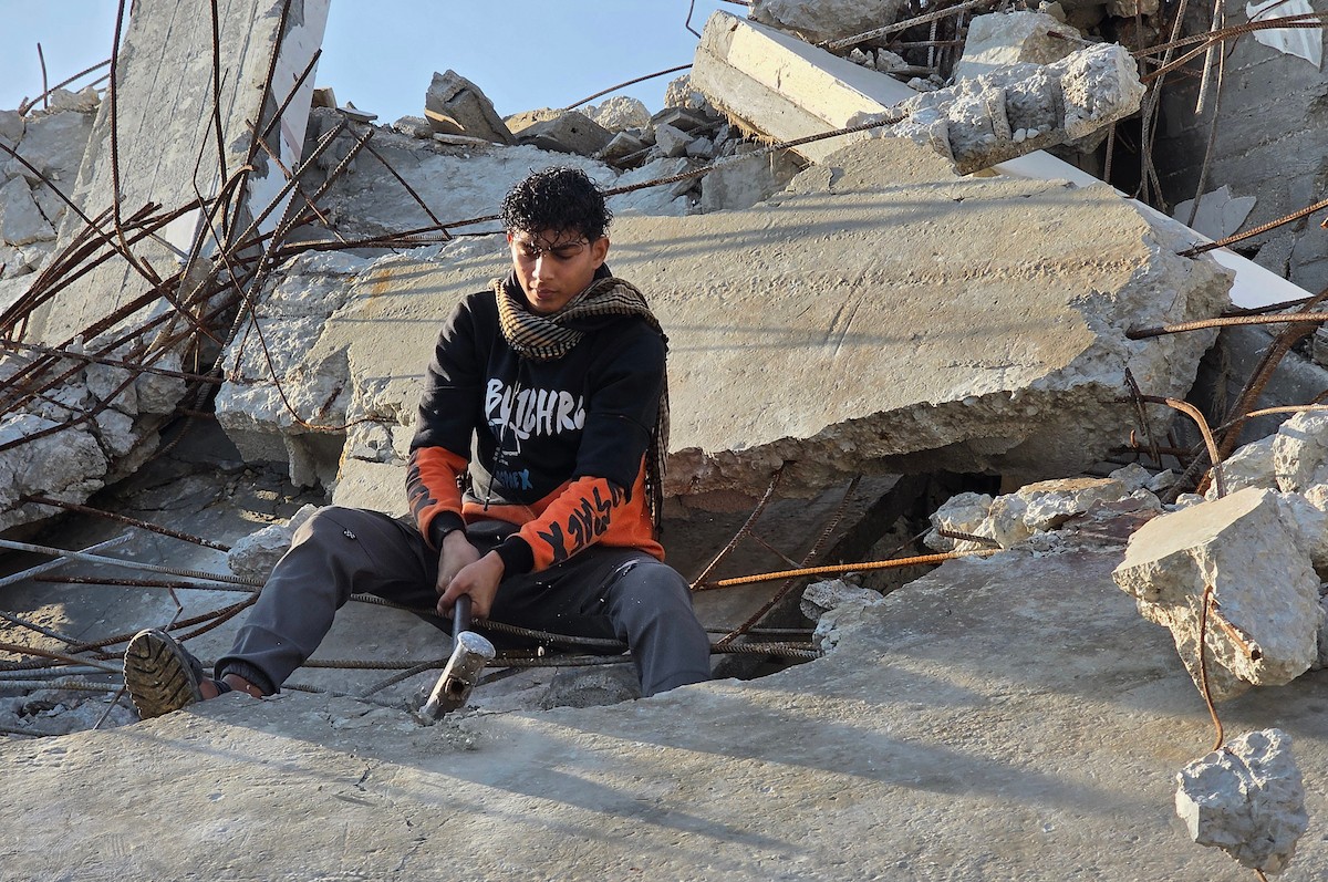 الفلسطيني هشام أبو عية يبني مأوى مؤقت لعائلته المكونة من ثمانية أفراد باستخدام قضبان حديدية استخرجها من أنقاض منزله الذي دُمر في هجمات إسرائيلية بمنطقة بطن السمين في خان يونس،  19 ديسمبر/كانون الأول 2025. تصوير: طارق محمد/ (APA )