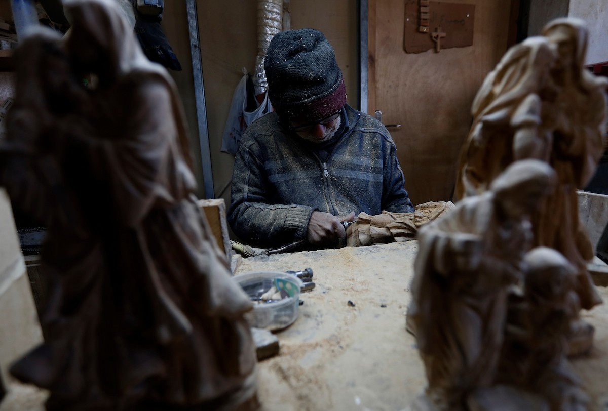 نحت خشب الزيتون في بيت لحم لصنع قطع فنية وهدايا متنوعة، تشمل منحوتات دينية وزخارف تقليدية وتذكارات، استعدادًا لعيد الميلاد، 18 ديسمبر/كانون الأول 2025 تصوير: مأمون وزواز/ (apa)