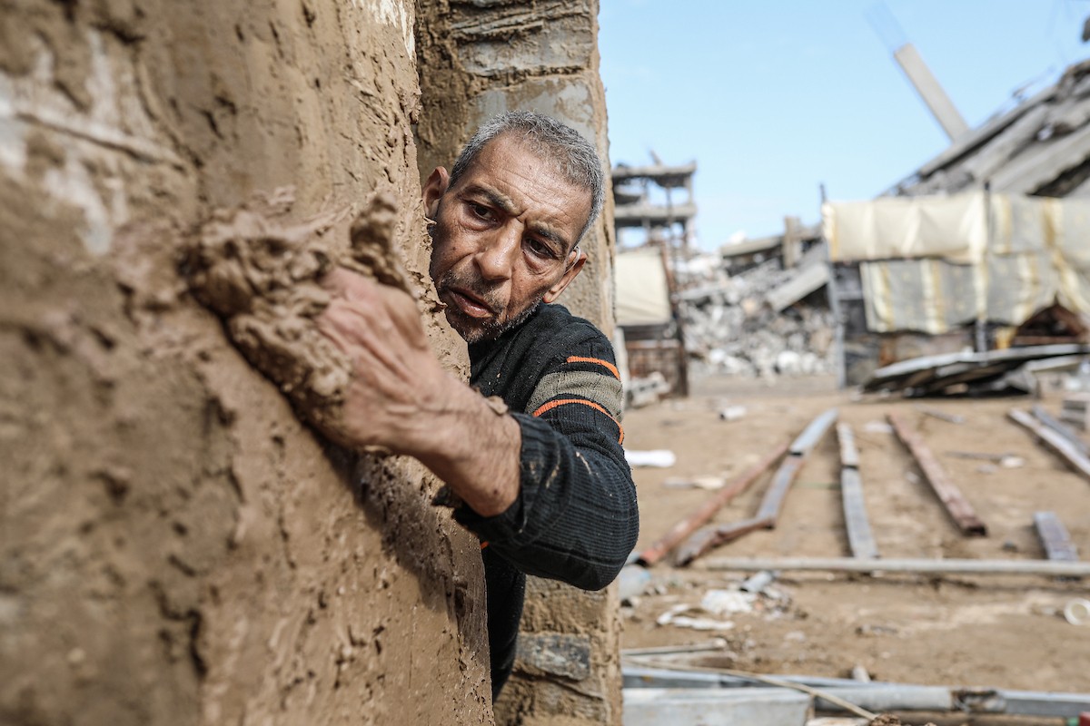 الفلسطيني أحمد المبحوح، مريض سرطان، يبني منزلاً طينياً بيديه في مخيم البريج للاجئين وسط قطاع غزة، 15 ديسمبر/كانون الأول 2025. عدسة: رمزي أبو عامر