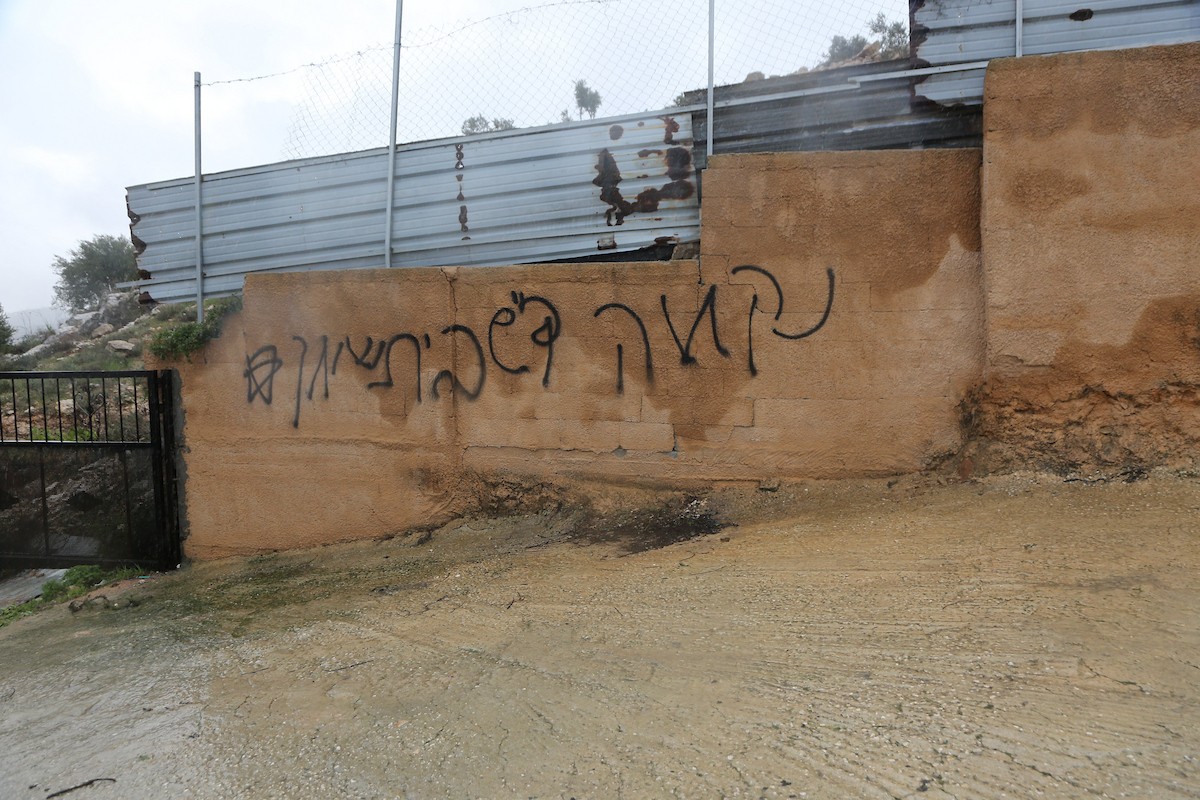 فلسطينيون يقفون في موقع حريق سيارة أشعله مستوطنون إسرائيليون في بلدة حوارة، جنوب نابلس في الضفة الغربية، 28 ديسمبر/كانون الأول 2025. صورة: محمد ناصر