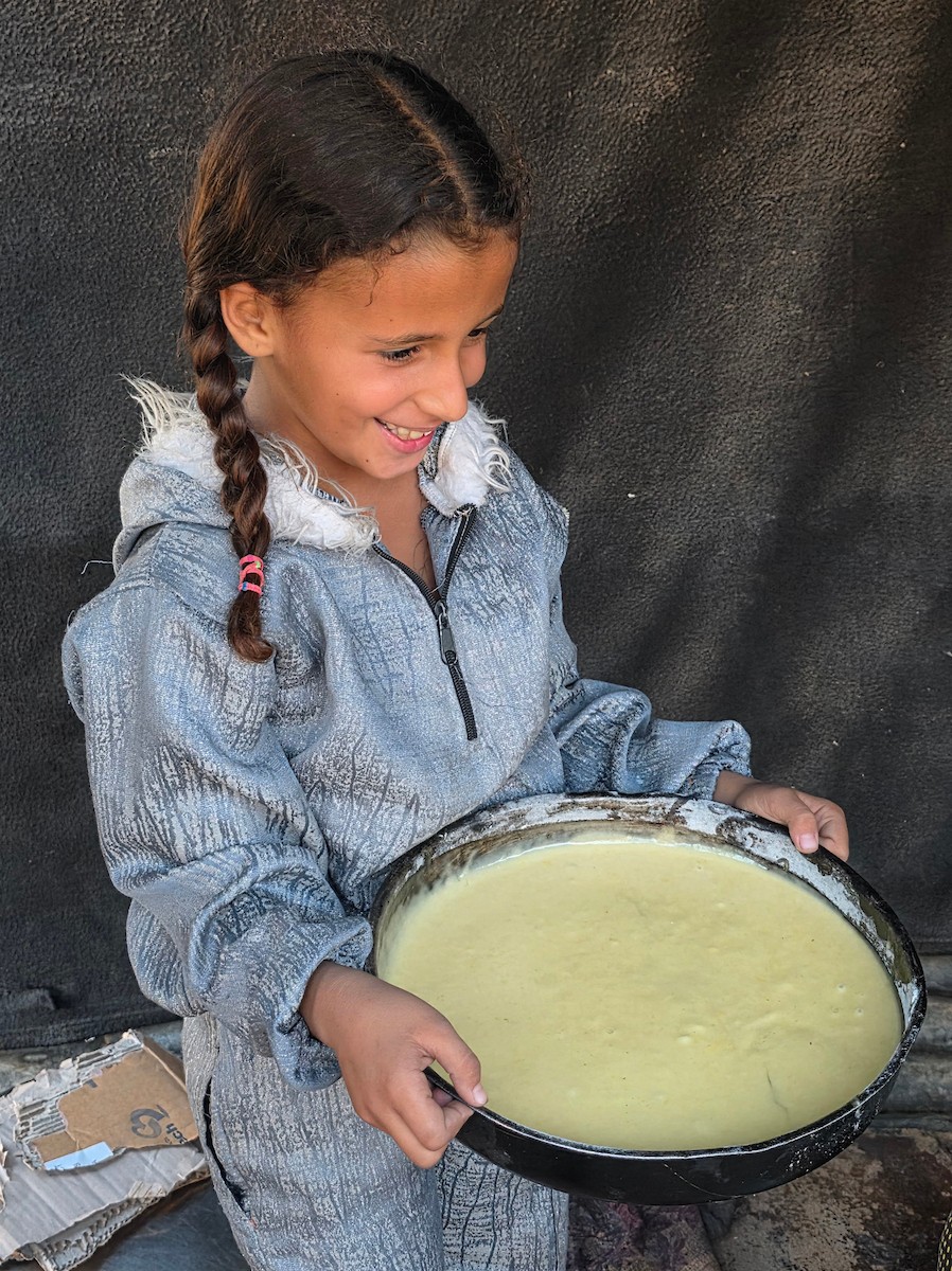 يتجمع فلسطينيون حول أفران طينية مؤقتة لطهي الطعام في قطاع غزة، بعد عشرة أسابيع من وقف إطلاق النار، في ظل شحّ غاز الطهي بسبب القيود الإسرائيلية على دخوله إلى القطاع