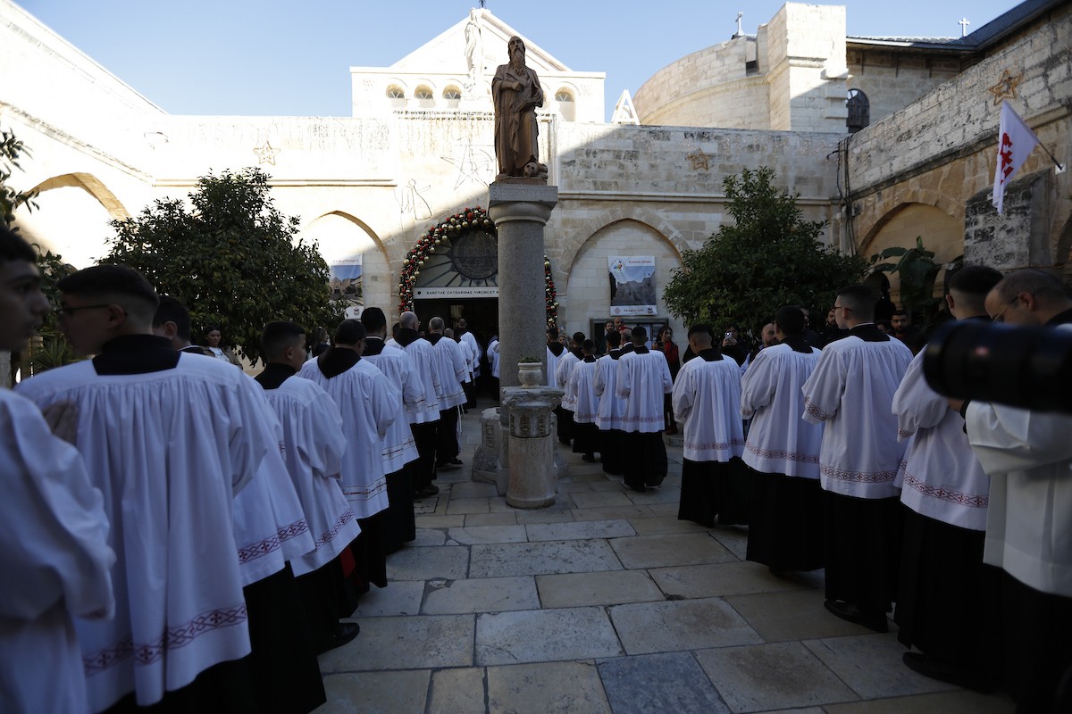 البطريرك اللاتيني للقدس، الكاردينال الإيطالي بييرباتيستا بيتسابالا يستقبل الحجاج والسياح لدى وصوله لترؤس قداس منتصف الليل في كنيسة المهد بمدينة بيت لحم، 24 ديسمبر/كانون الأول 2025،  (صور: مأمون وزواز/ apa)