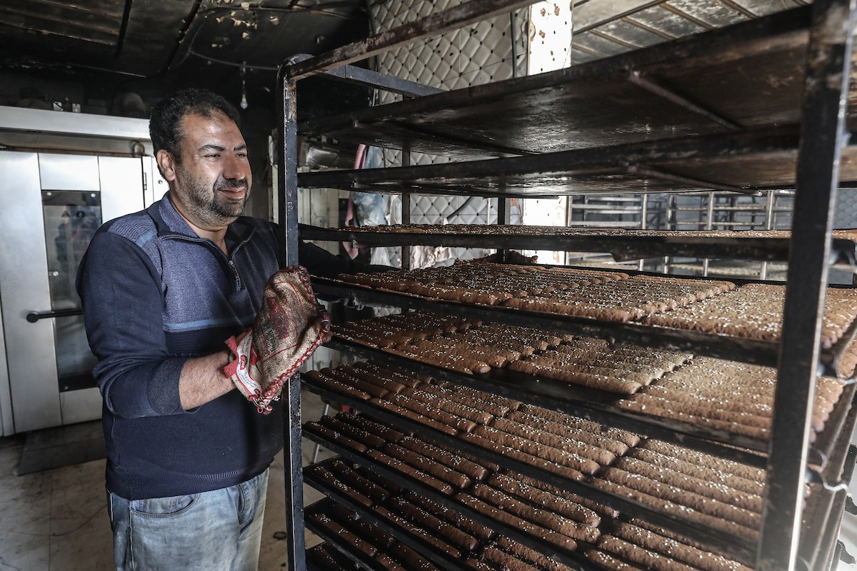 عمال فلسطينيون يعيدون تشغيل أحد أقدم المخابز في مخيم النصيرات للاجئين بعد إغلاقه لمدة عامين بسبب الحرب (3).jpg