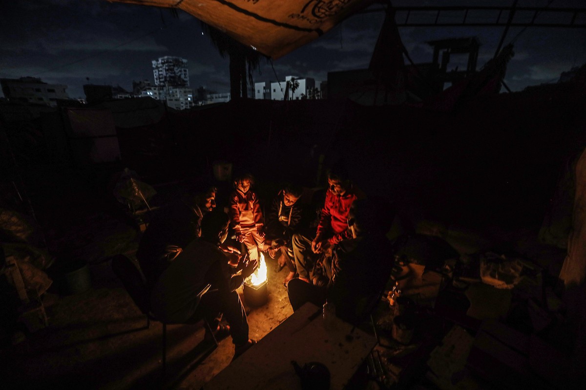 عائلات نازحة تتجمع حول النار للتدفئة في مدينة غزة في ظل الأجواء الباردة، 30 ديسمبر/كانون الأول 2025. تصوير: عمر أشتوي