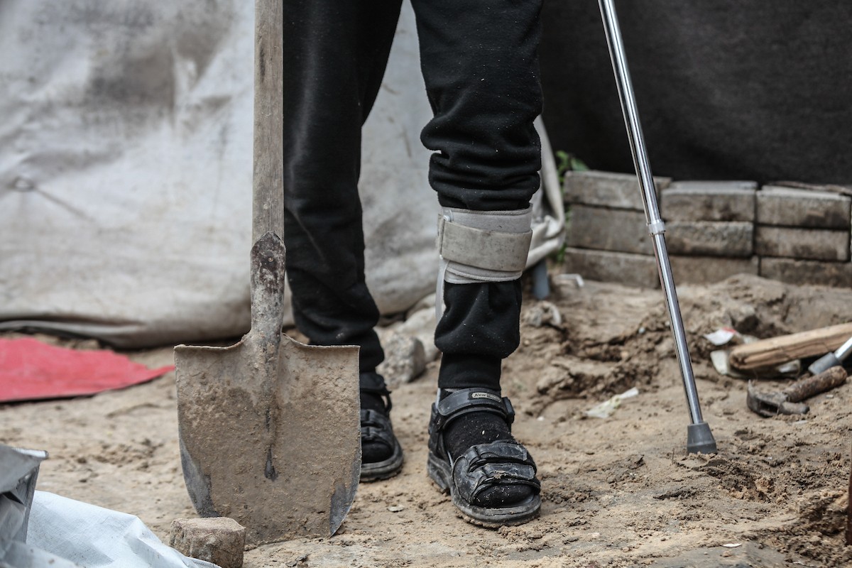 أحمد أبو ليلى أب لخمسة أطفال أصيب في الحرب  يحاول إصلاح خيمته بعد أن تضررت جراء الأمطار الغزيرة والرياح العاتية التي اجتاحت مخيم النصيرات وسط قطاع غزة، 28 ديسمبر/كانون الأول 2025.تصوير: معز صالحي